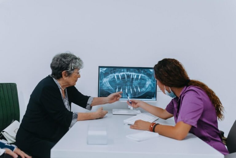 Dentist discussing a dental implant X-ray with a patient in Guildford